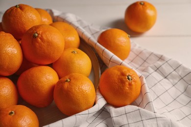 Many fresh ripe tangerines on white wooden table