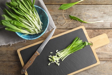 Photo of Flat lay composition with wild garlic or ramson on wooden table