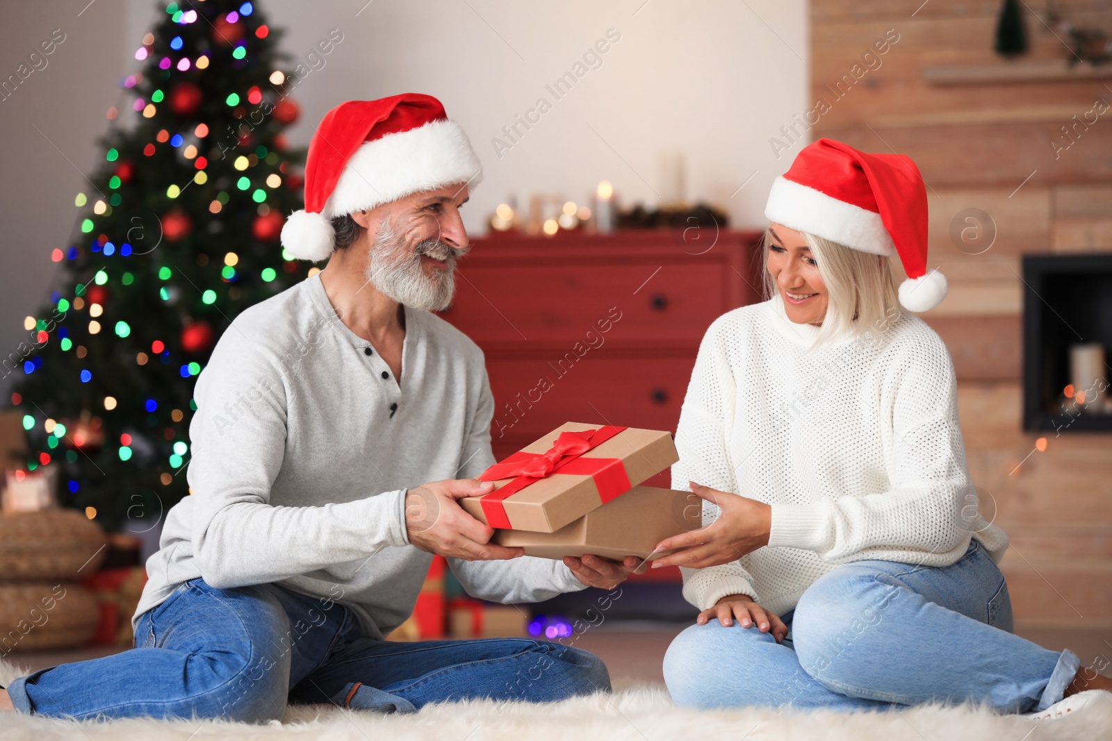 Photo of Happy couple opening Christmas gift at home