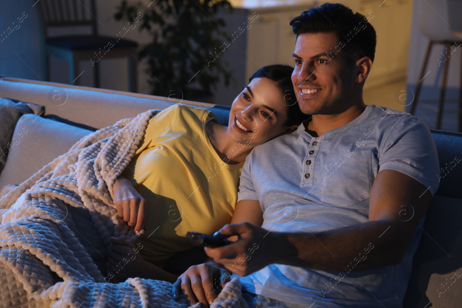 Photo of Couple watching movie on sofa at night