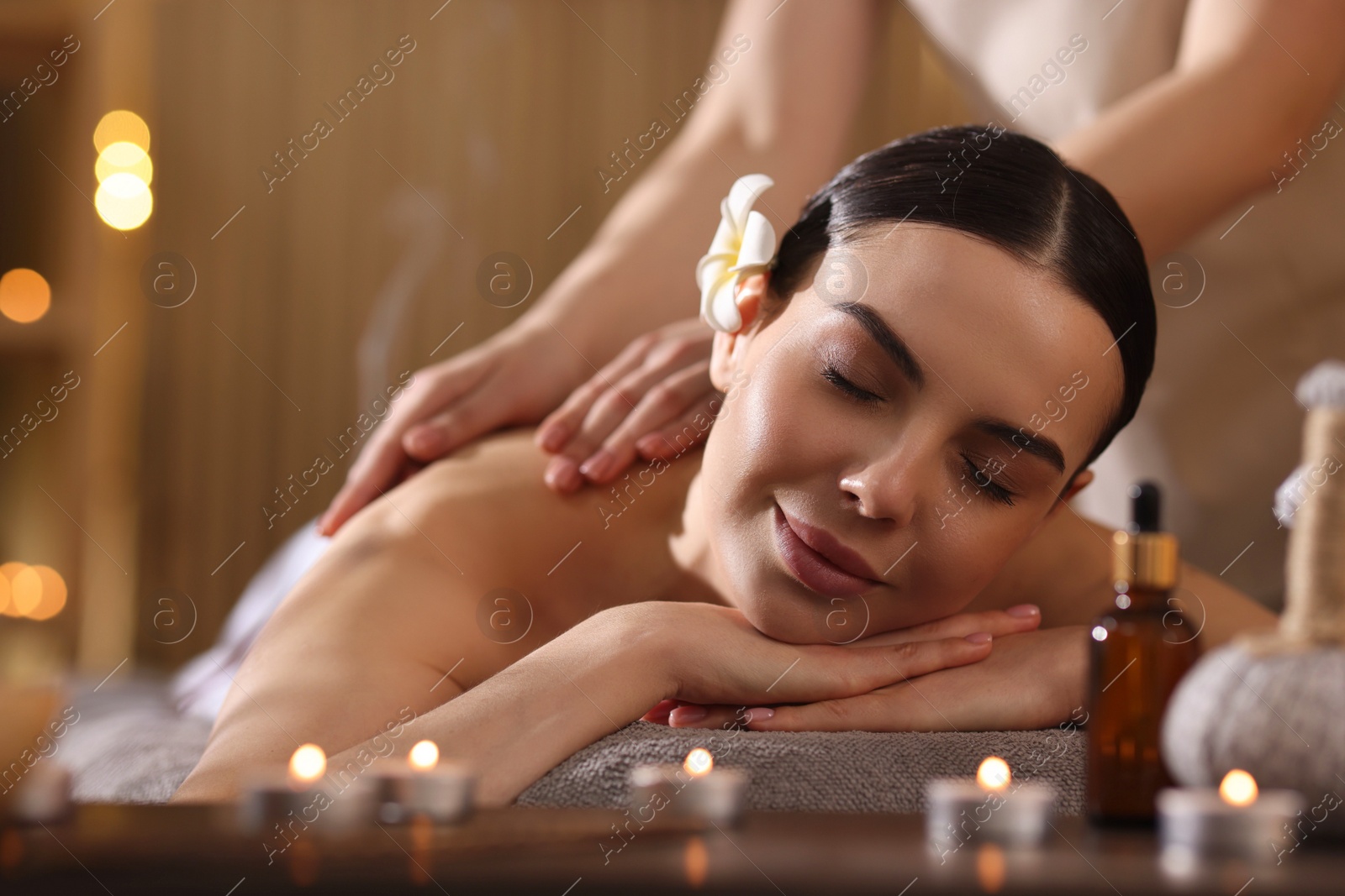 Photo of Spa therapy. Beautiful young woman lying on table during massage in salon