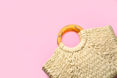 Elegant woman's straw bag on pink background, top view. Space for text