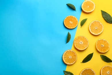 Photo of Slices of delicious oranges on color background, flat lay. Space for text