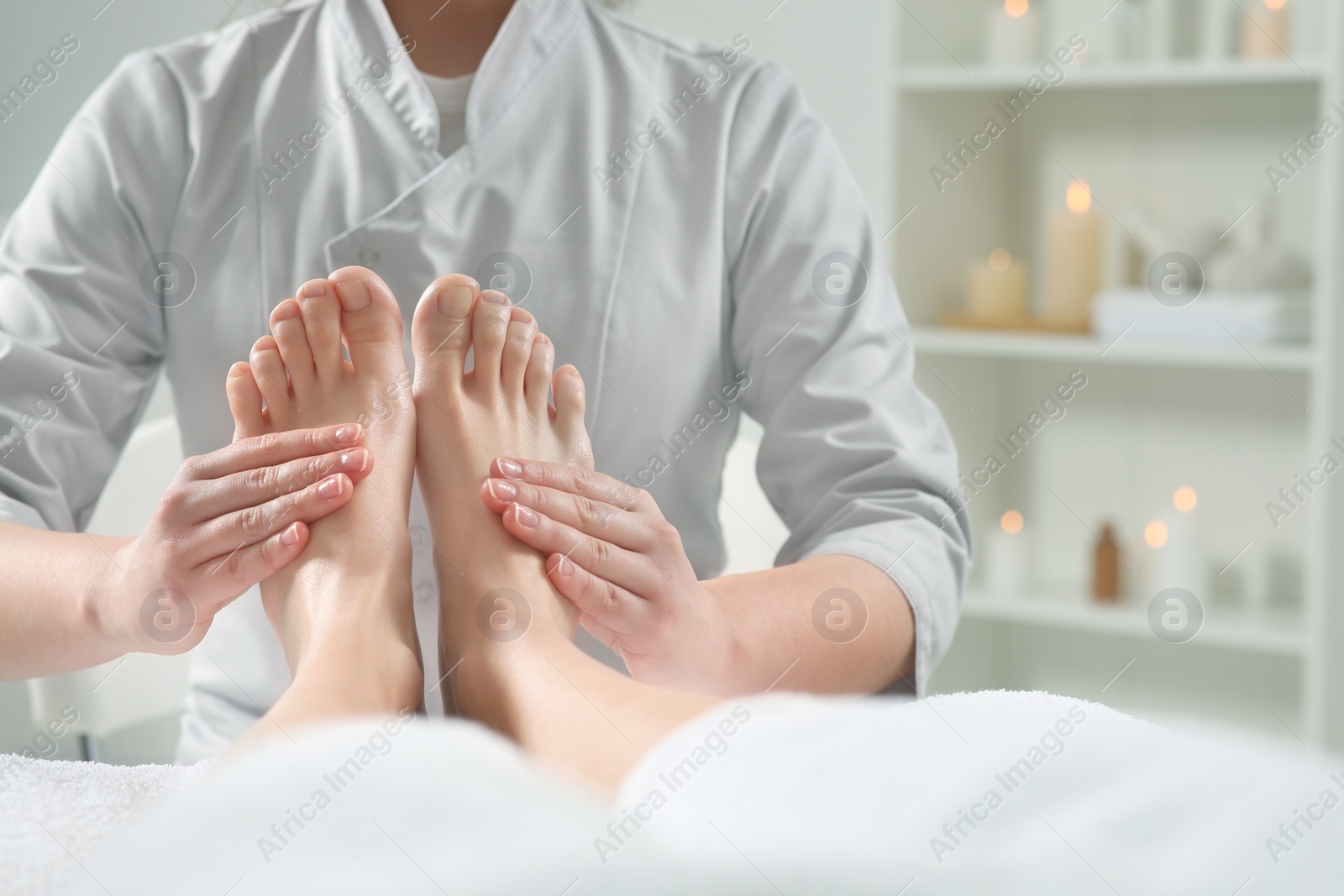 Photo of Woman receiving feet massage in spa salon, closeup