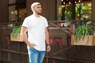 Photo of Young man wearing white t-shirt on street