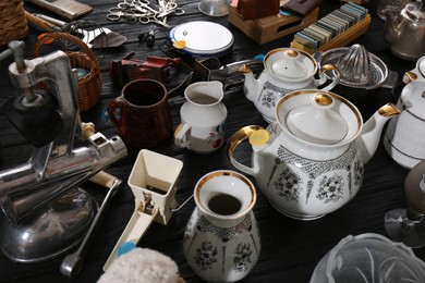 Photo of Many different stuff on black wooden table. Garage sale