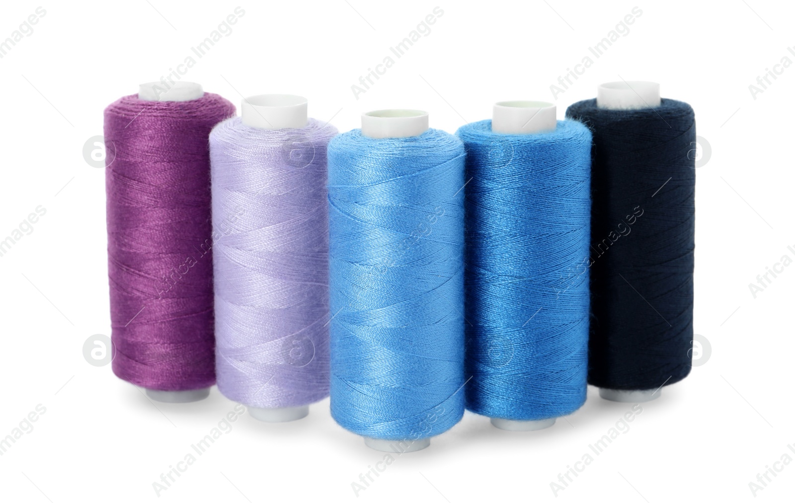 Photo of Set of different colorful sewing threads on white background