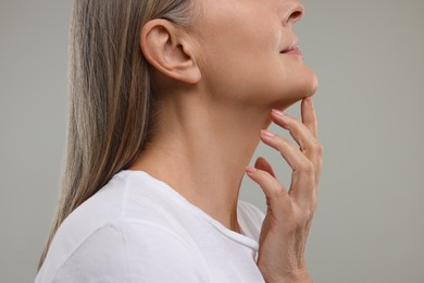 Photo of Mature woman with healthy skin on grey background, closeup