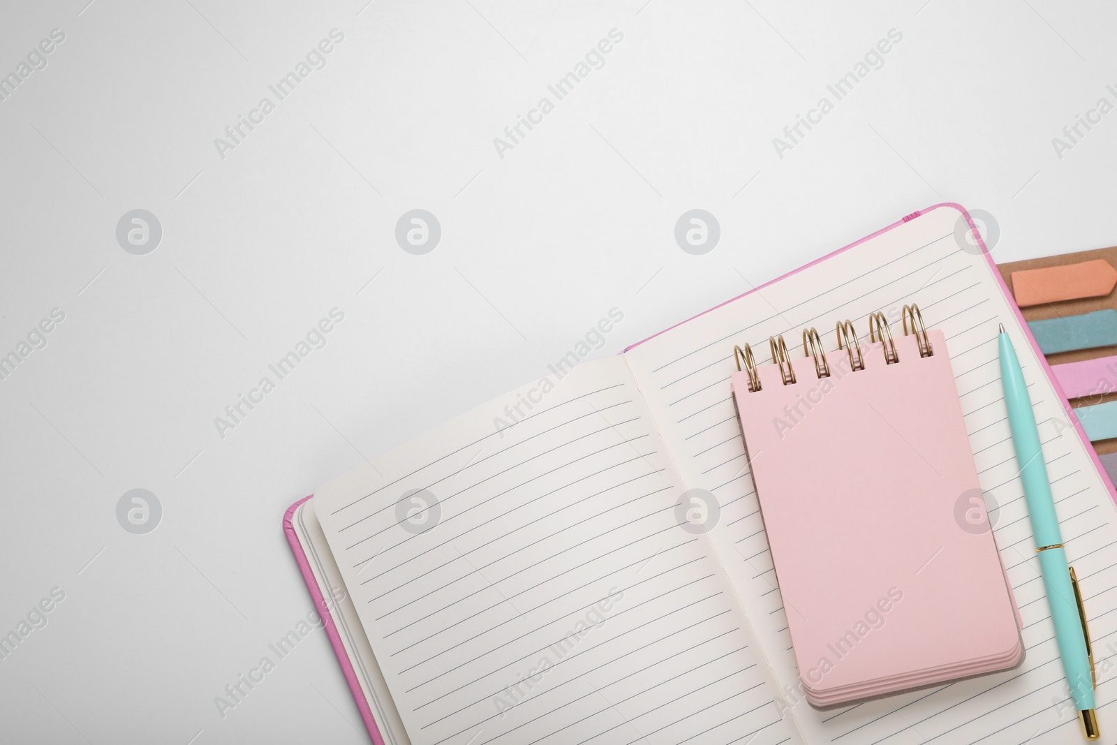 Photo of Open planner and stationery on white background, flat lay. Space for text