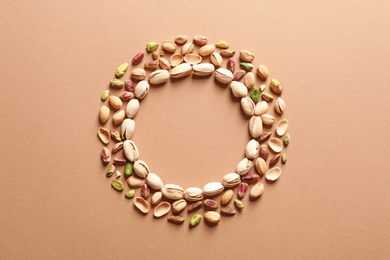 Photo of Round frame made of organic pistachio nuts, flat lay. Space for text