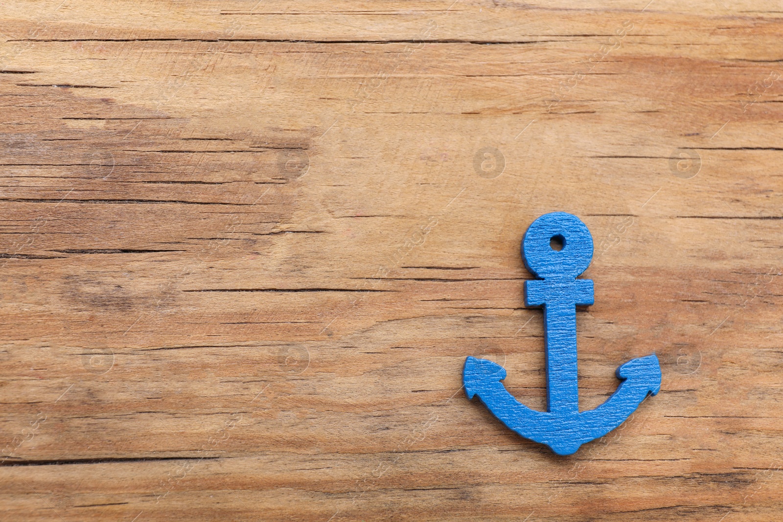 Photo of Anchor figure on wooden table, top view with space for text