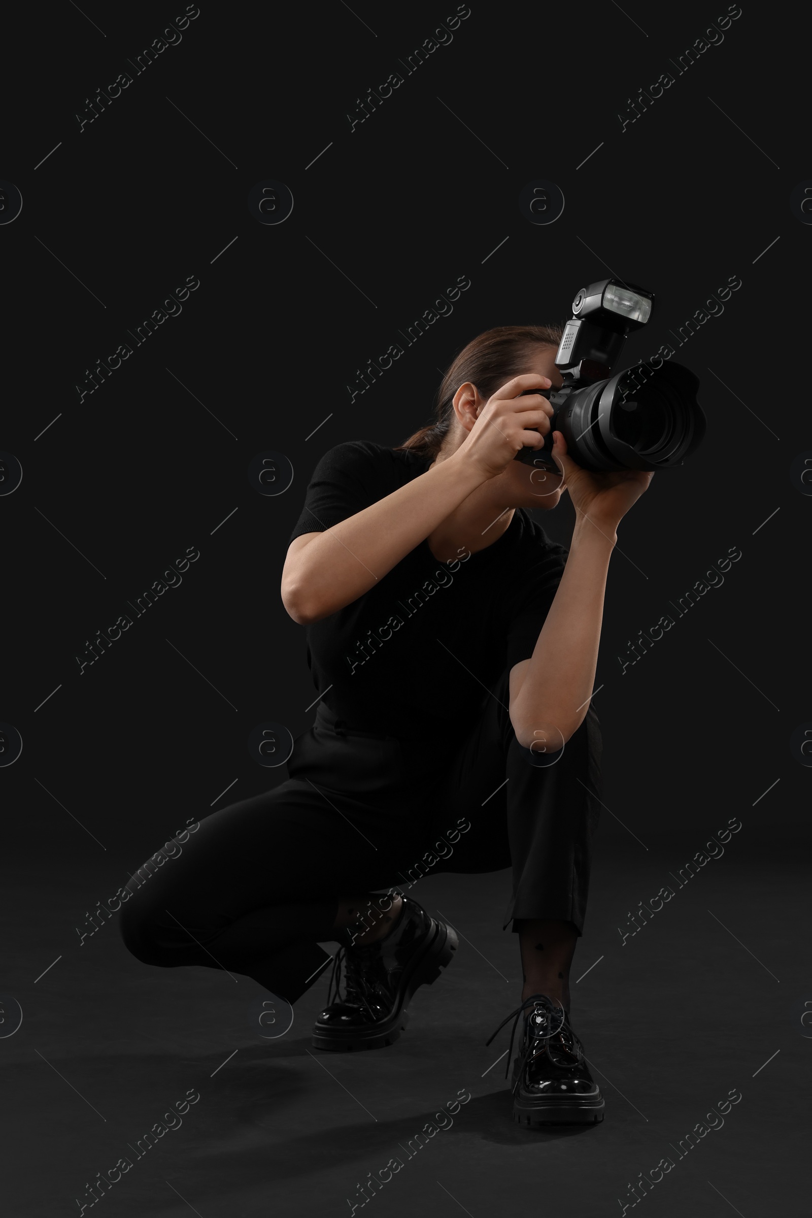 Photo of Professional photographer taking picture on black background