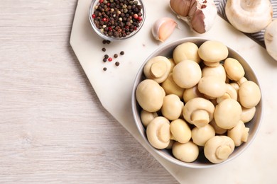 Photo of Tasty marinated mushrooms, garlic and pepper on white wooden table, flat lay. Space for text