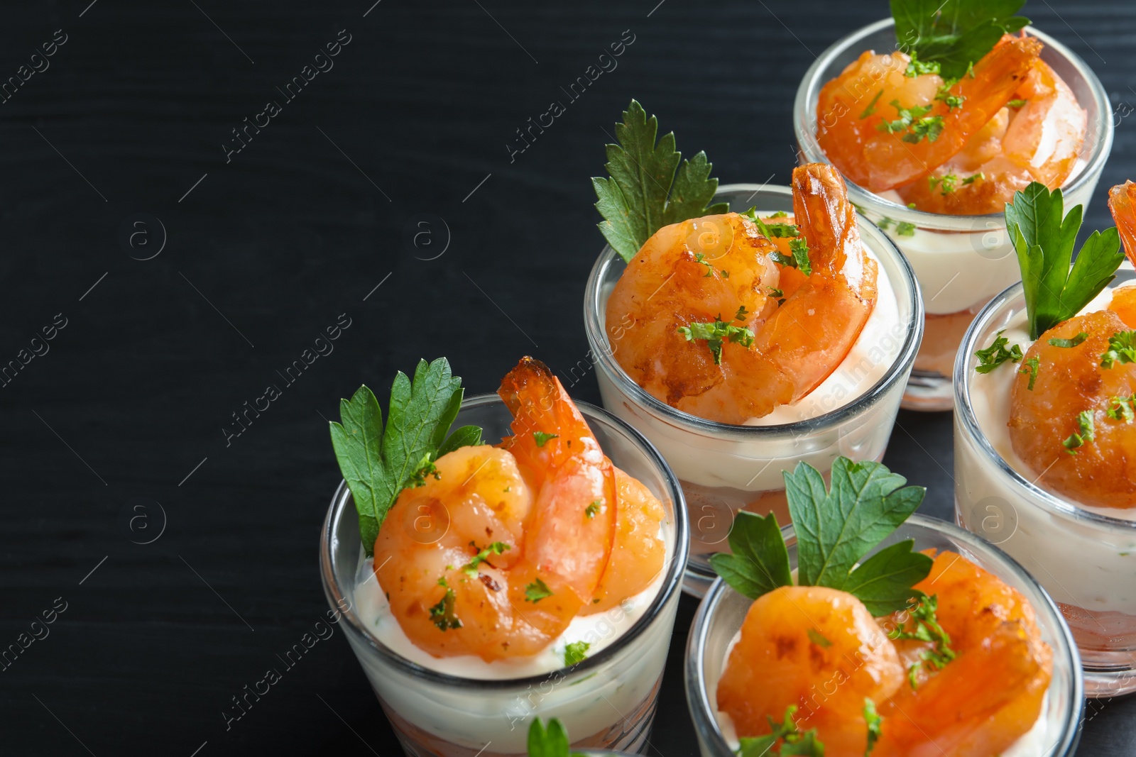 Photo of Glasses with fried shrimps and sauce on wooden background