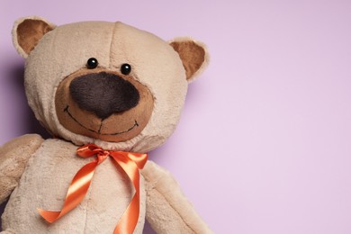 Cute teddy bear on light pink background, top view. Space for text