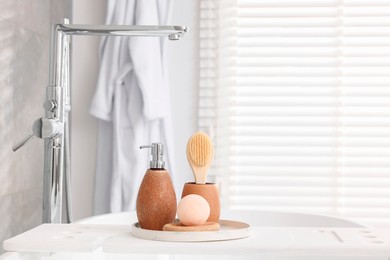 Different personal care products and accessories on bath tub in bathroom