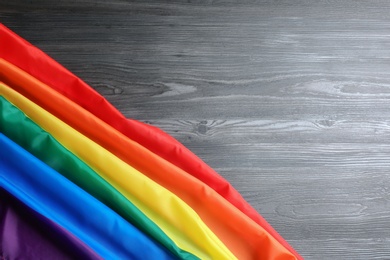 Bright rainbow gay flag on wooden background, top view with space for text. LGBT community