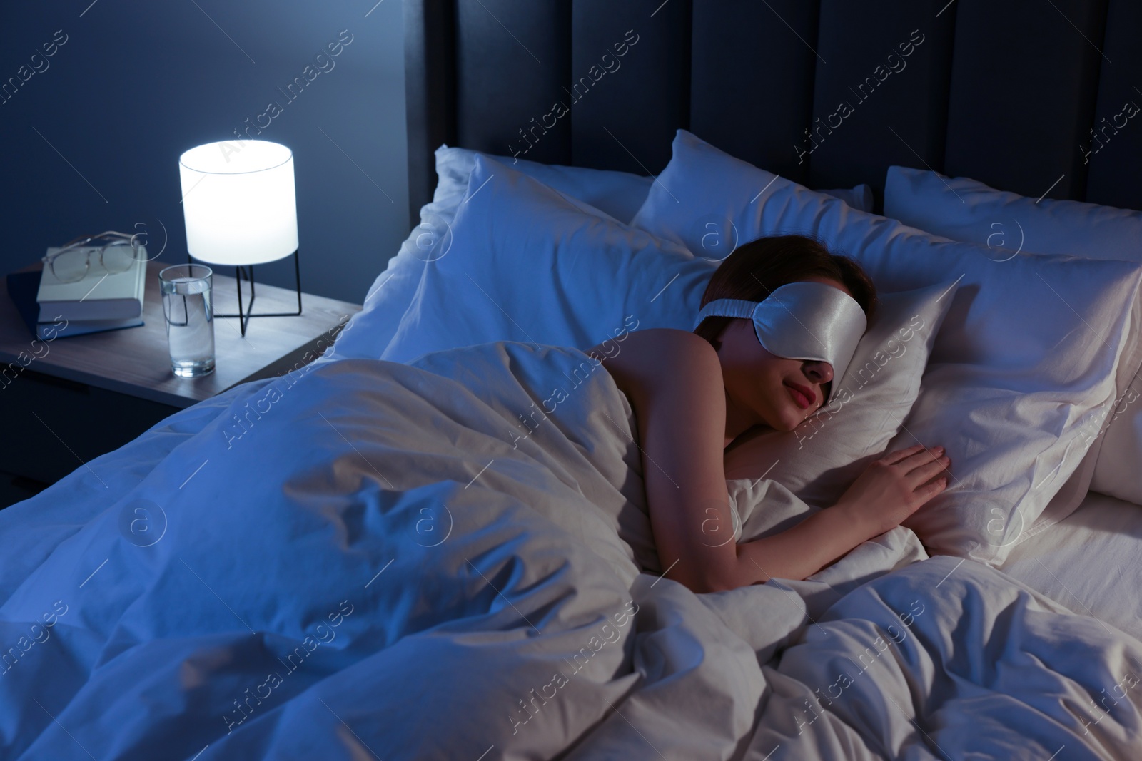 Photo of Woman with mask sleeping in bed at night