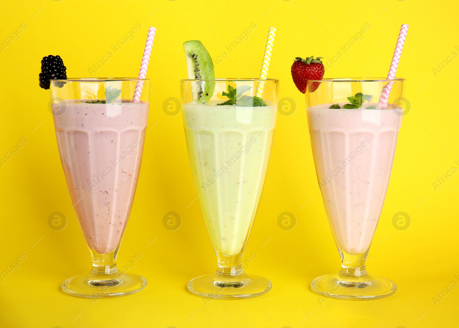 Photo of Tasty fresh milk shakes with berries on white background