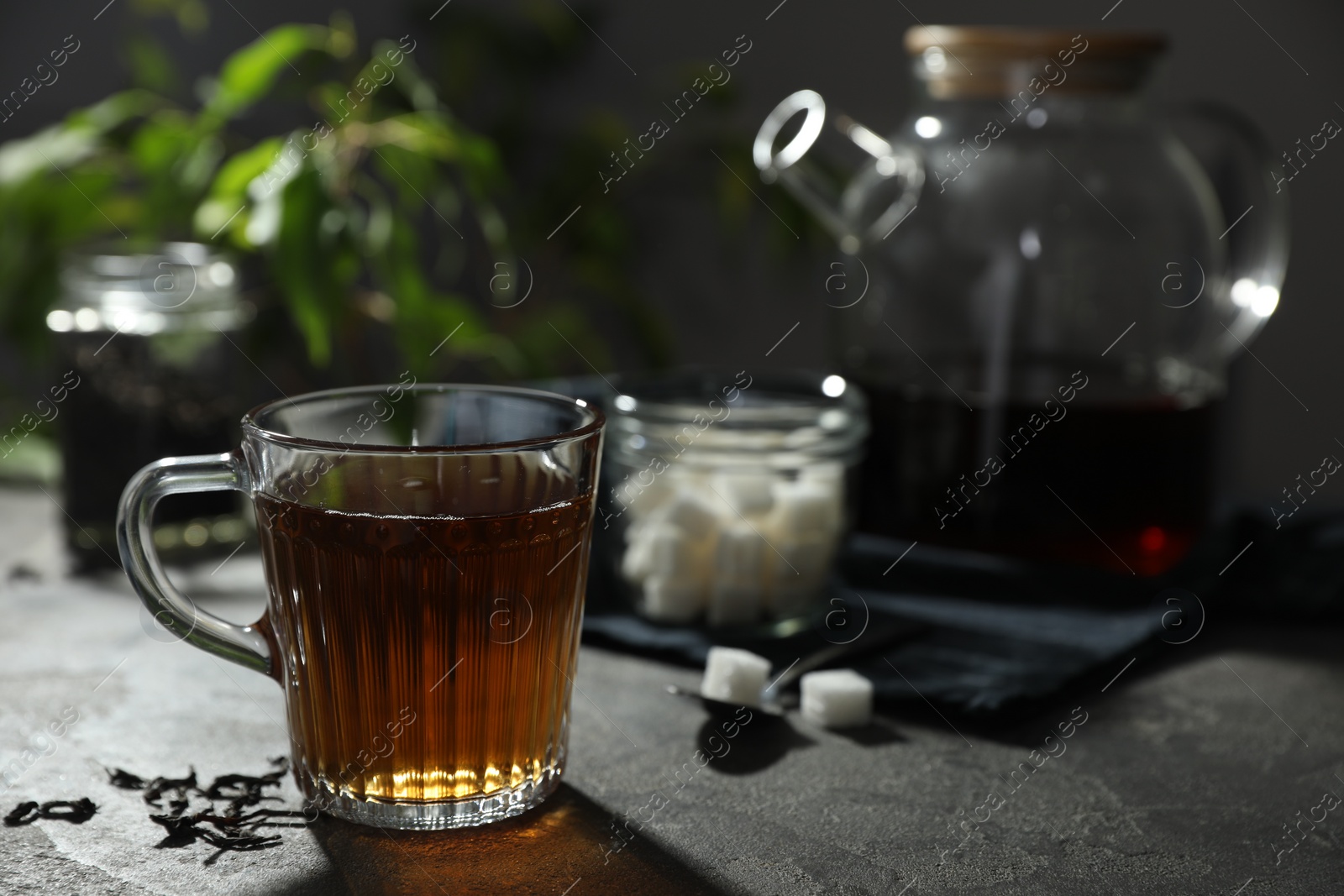 Photo of Tasty hot tea in cup on grey table, closeup. Space for text