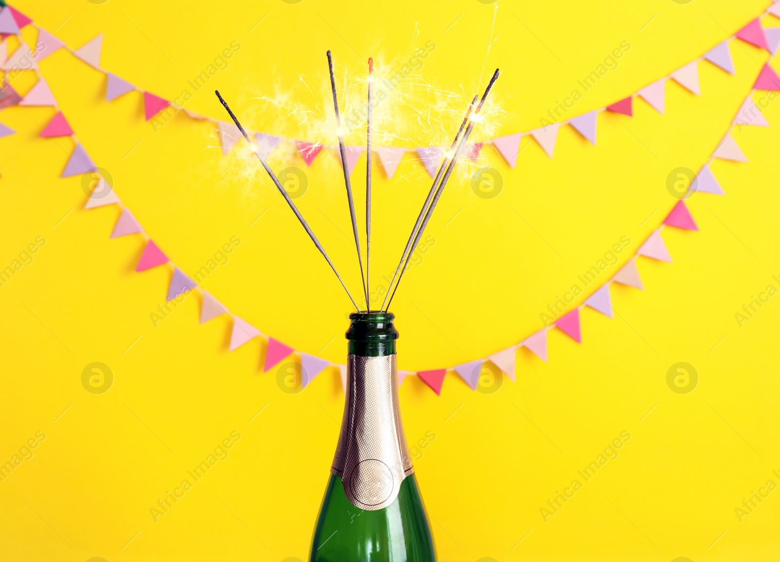 Photo of Creative composition with bottle of champagne and sparklers on color background