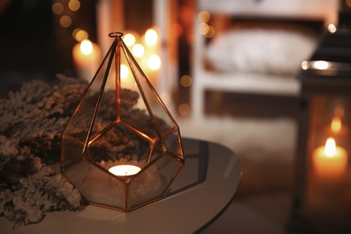 Stylish lantern with burning candle and Christmas decor on table indoors, space for text. Interior design