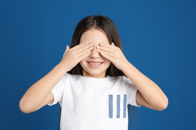 Portrait of cute little girl on blue background