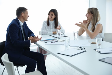 Photo of Office employees talking at table during meeting