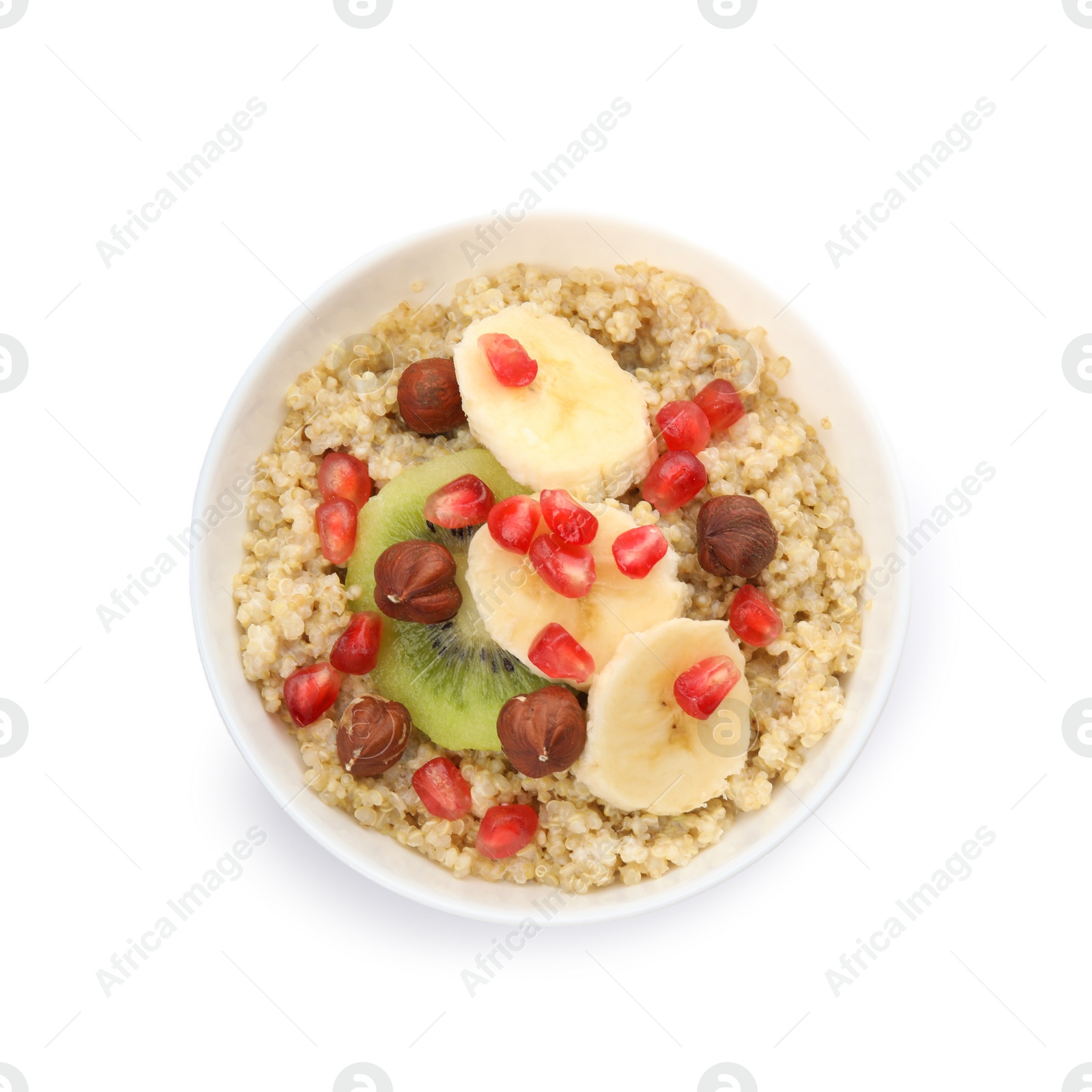 Photo of Bowl of quinoa porridge with hazelnuts, kiwi, banana and pomegranate seeds on white background, top view