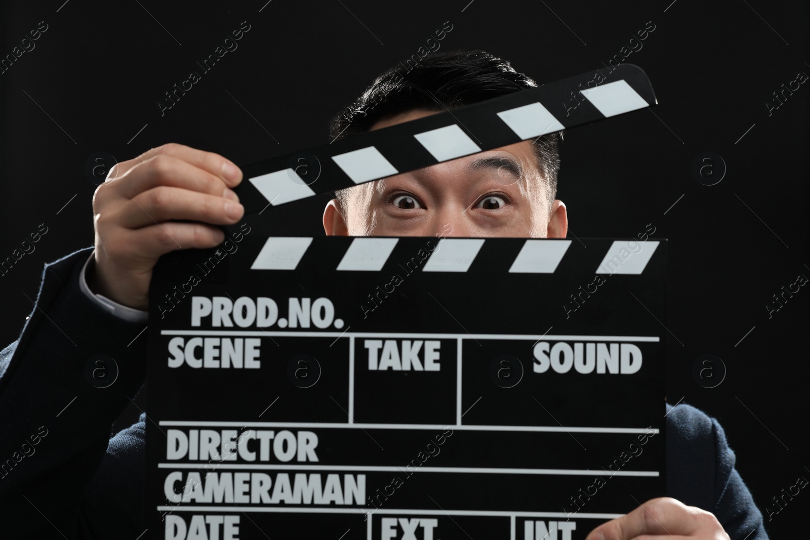 Photo of Asian actor with clapperboard on stage, closeup. Film industry