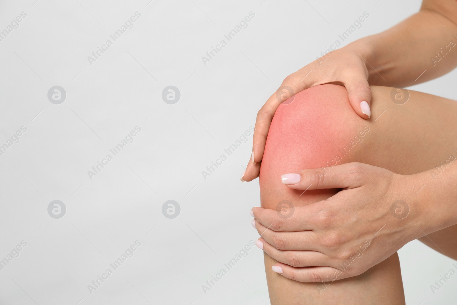 Photo of Woman having knee problems on grey background, closeup with space for text