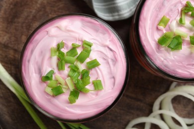 Photo of Glass jars of herring under fur coat on tray, flat lay. Traditional Russian salad