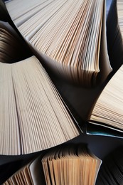 Collection of different books on white shelf, above view