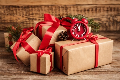 Christmas gifts and alarm clock on wooden table. Boxing day