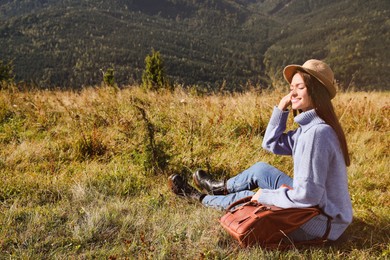 Young woman enjoying beautiful mountain landscape on sunny day