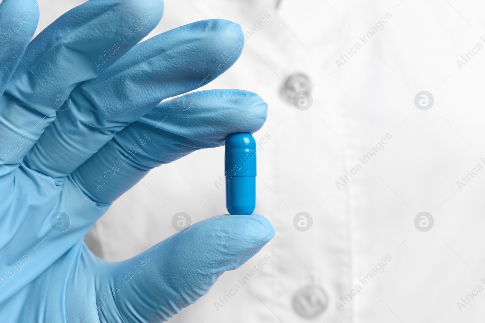 Photo of Doctor holding pill, closeup. Space for text