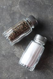 Photo of Salt and pepper shakers on grey textured table, top view