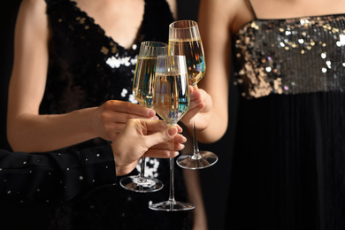 Women clinking glasses of champagne at party, closeup