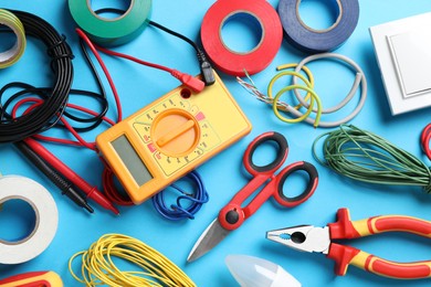 Photo of Flat lay composition with electrician's tools and accessories on light blue background