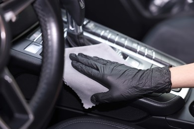 Photo of Woman wiping her modern car with rag, closeup