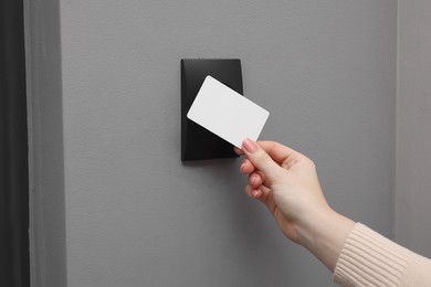 Photo of Woman opening magnetic door lock with key card, closeup. Home security