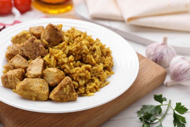 Delicious rice with chicken served on white table, closeup