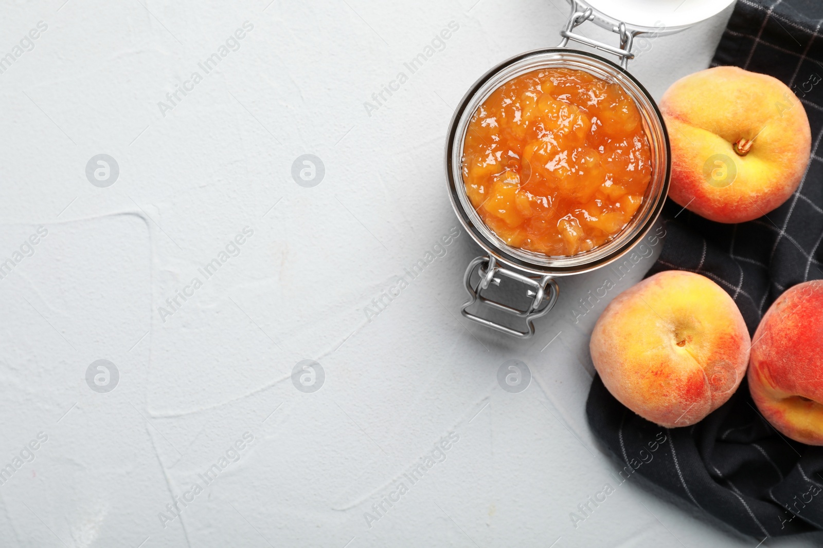 Photo of Flat lay composition with jar of tasty peach jam and fresh fruit on gray table