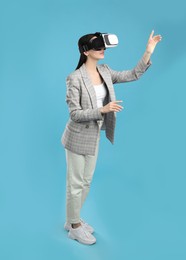 Woman using virtual reality headset on light blue background
