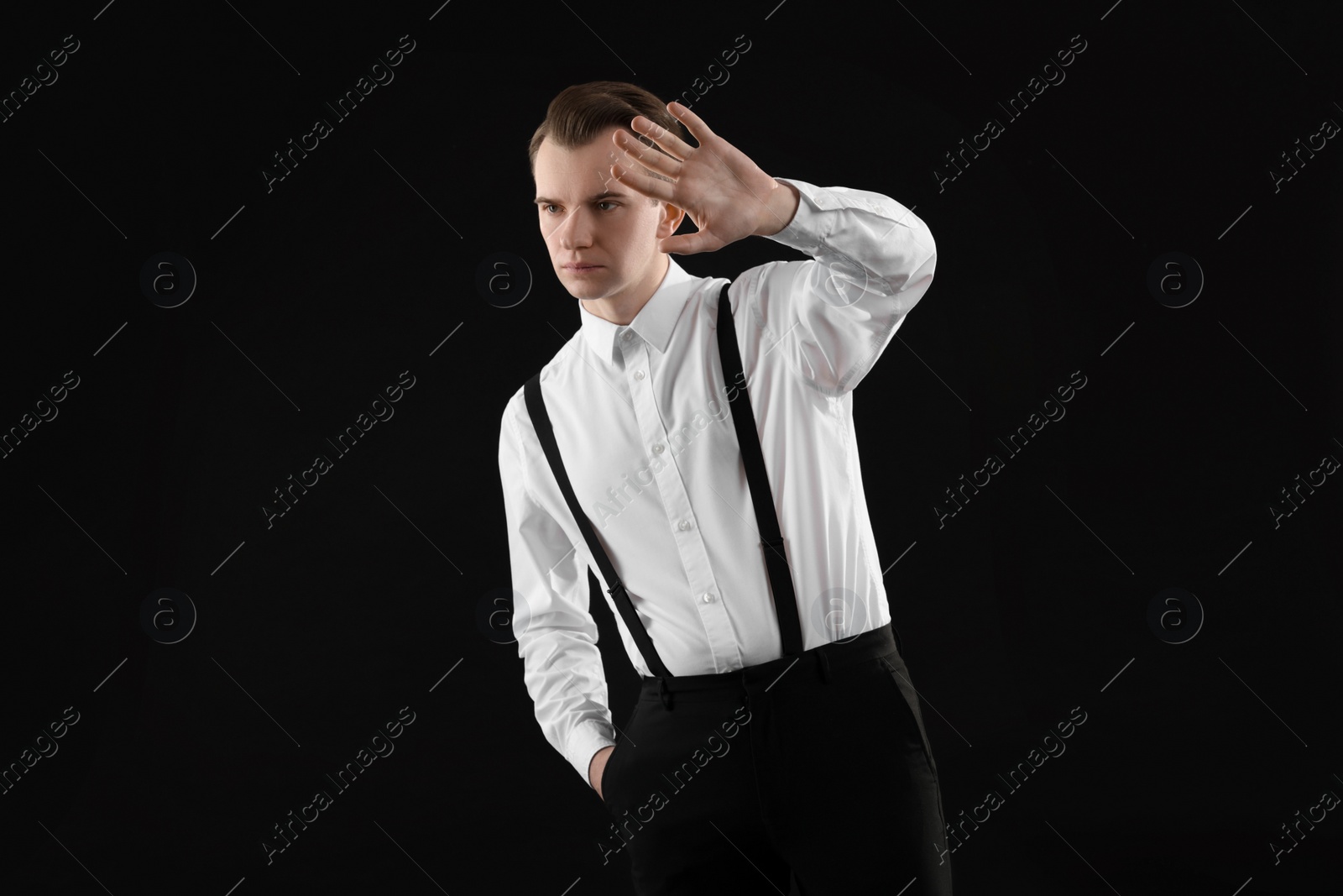 Photo of Young man covering face with hand on black background