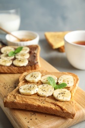 Photo of Tasty toasts with banana, mint and chia seeds on wooden board