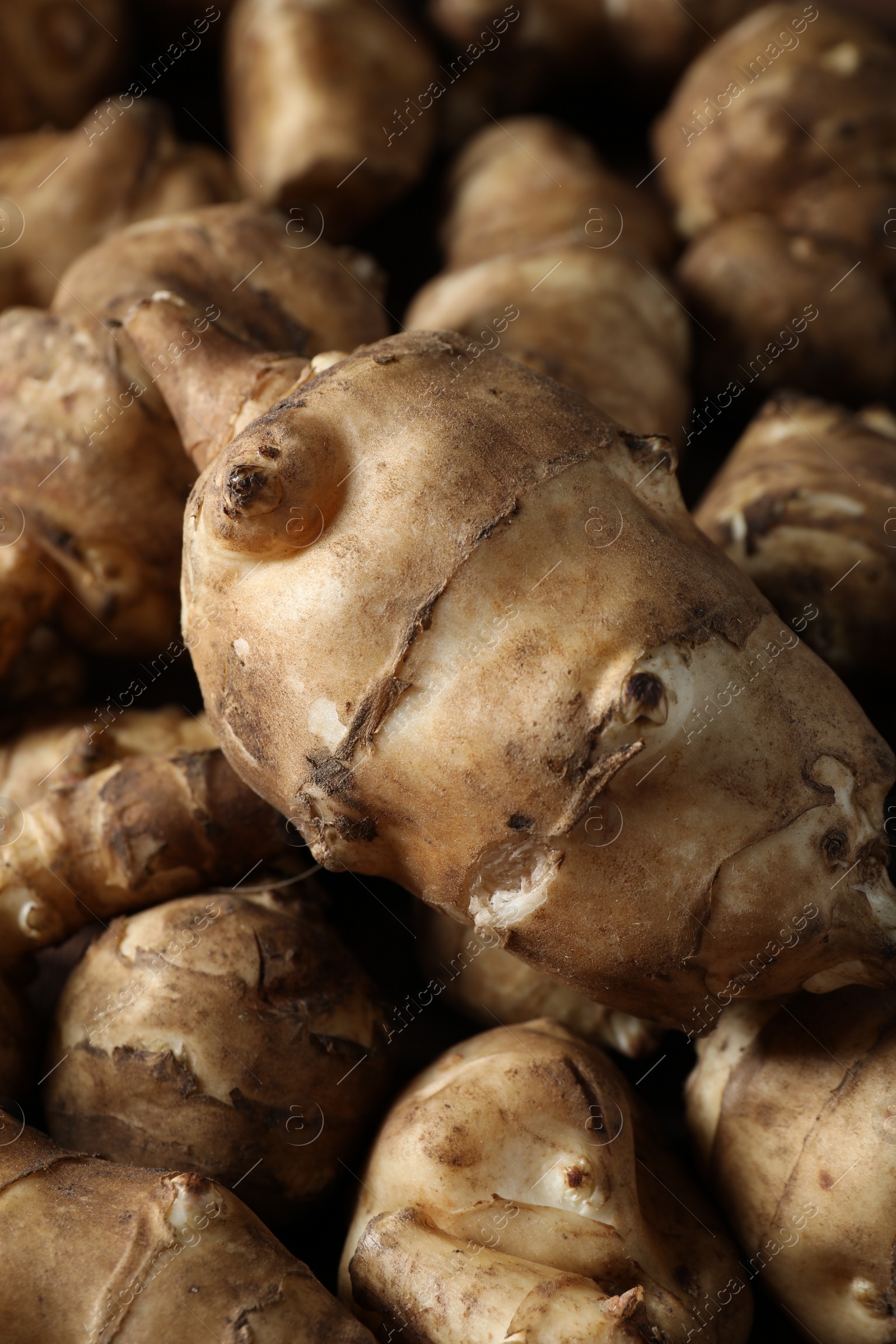 Photo of Many fresh Jerusalem artichokes as background, closeup