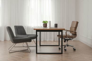 Photo of Director's office with large wooden table and comfortable armchairs. Interior design