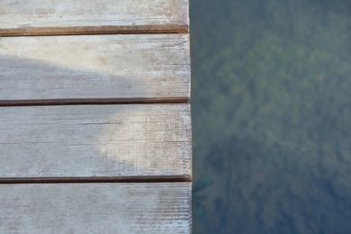 Wooden pier near pond. Space for text