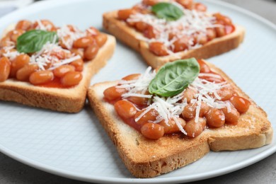 Photo of Toasts with delicious canned beans on plate, closeup